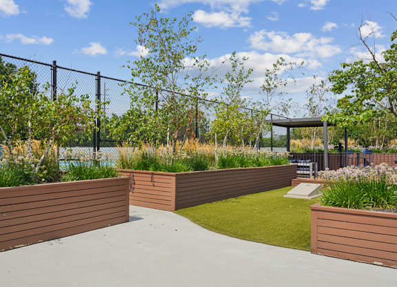 A park with a wooden fence and a bench.