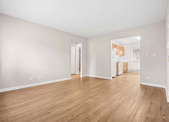 A large empty room with wooden floors and white walls.