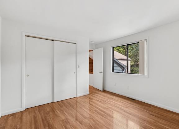 A room with a white wall and a window showing a balcony.