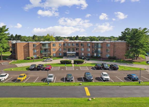 A parking lot in front of a multi-story brick building.