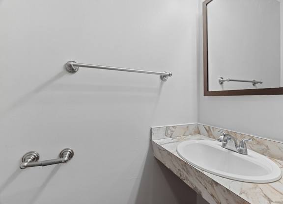 A bathroom with a marble sink and a mirror.