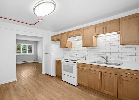 A kitchen with wooden cabinets and white appliances.