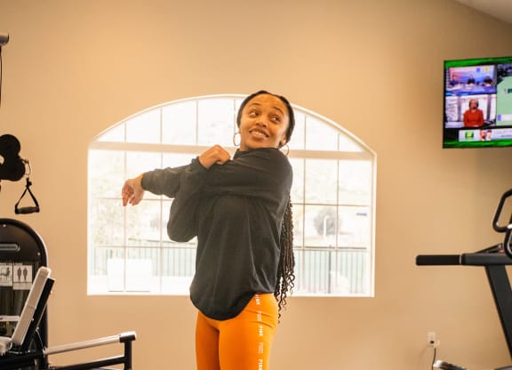 a young woman standing on a yoga mat in a fitness room