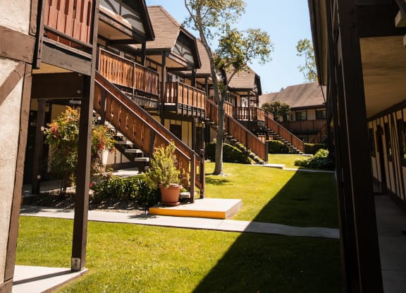 a row of wooden houses with stairs in a yard at Oak Park Apartments, California, 93463
