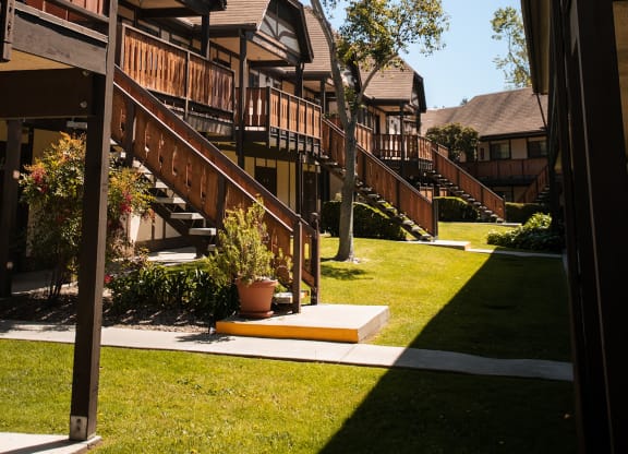 a row of wooden houses with stairs in a yard at Oak Park Apartments, California