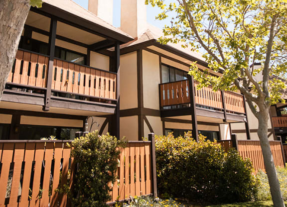 a view of the exterior of a building with benches at Oak Park Apartments, Solvang, CA