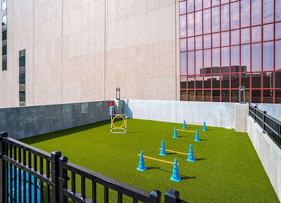 A playground with a yellow swing set and blue cones. at Sora Apartments, Minneapolis, MN, 55415