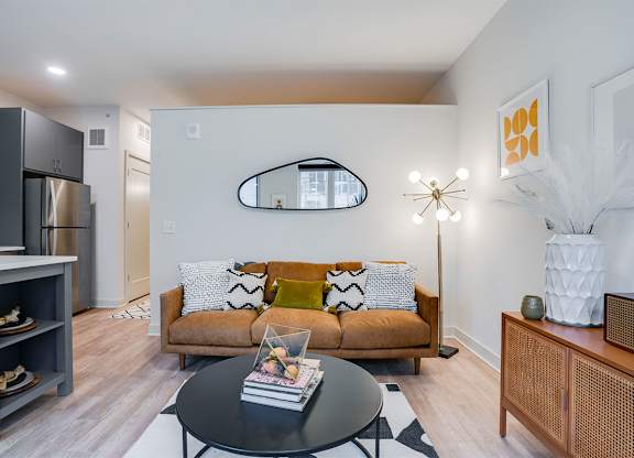 A living room with a brown couch and a black coffee table. at Sora Apartments, Minneapolis, Minnesota