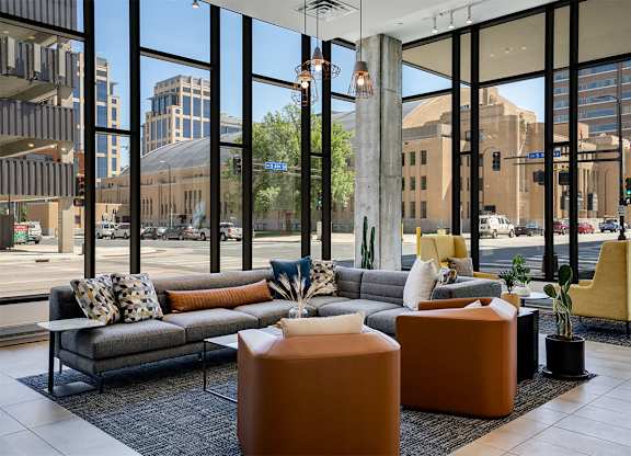 Lobby chairs with large windows in the background at Sora Apartments, Minneapolis, MN, 55415