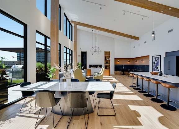 A modern lounge with a large table and chairs at Sora Apartments, Minneapolis 55415