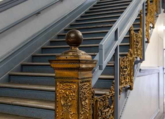 a set of stairs with a metal railing and a gold column in front of them at Residences at South High, Pittsburgh, PA ?