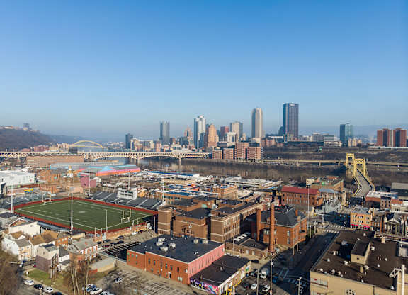 an aerial view of the city with a football field