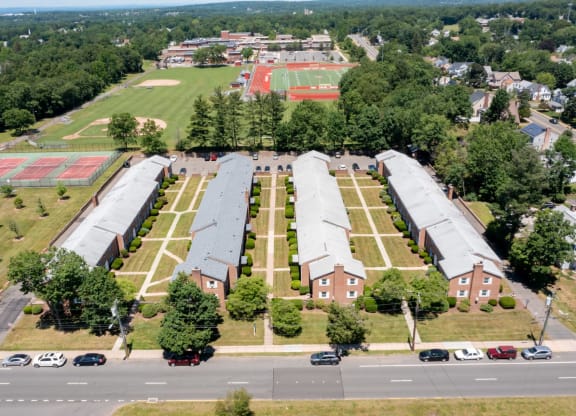 an aerial view of the campus with a field of trees and a parking lot