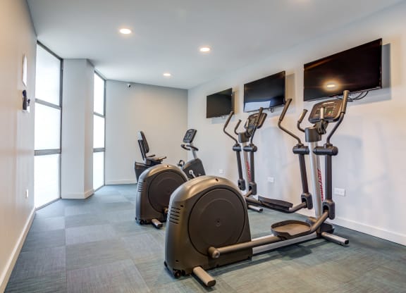 a gym with cardio machines and flat screen televisionsat The Township at St. Charles, St. Charles
