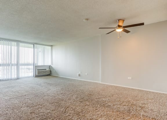 an empty living room with a ceiling fan at The Township at St. Charles, Illinois