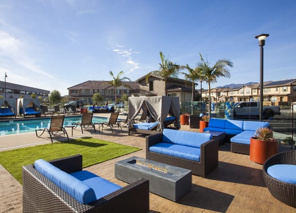 a pool area with lounge chairs and a fire pit at Arrive Los Carneros Apartments, Goleta