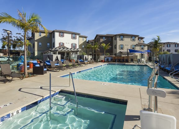 a swimming pool with several apartment buildings in the background at Arrive Los Carneros Apartments, Goleta, CA