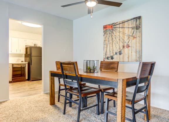 a dining room table with four chairs and a ceiling fan at The Township at St. Charles, Illinois