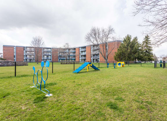 a park with agility equipment and a building in the background at The Township at St. Charles, St. Charles, IL, 60174