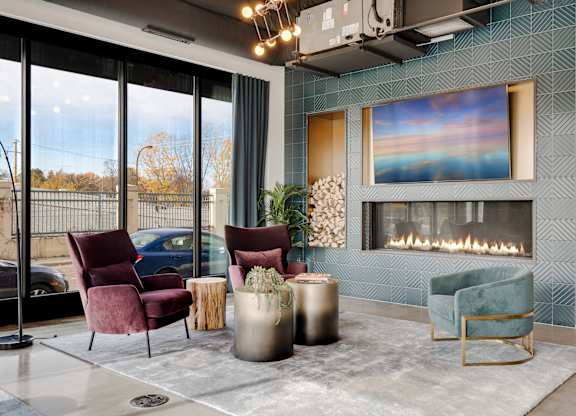 A room with a fireplace and a painting on the wall. at The Shale, Minnesota, 55406