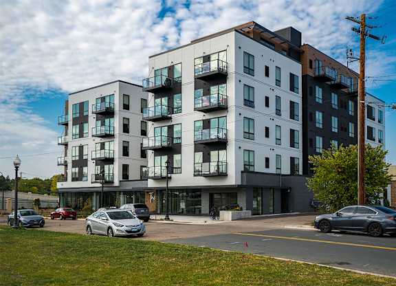 A modern apartment building with cars parked in front. at The Shale, Minnesota, 55406