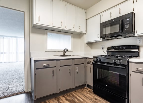 a kitchen with white cabinets and black appliancesat The Township at St. Charles, St. Charles, Illinois