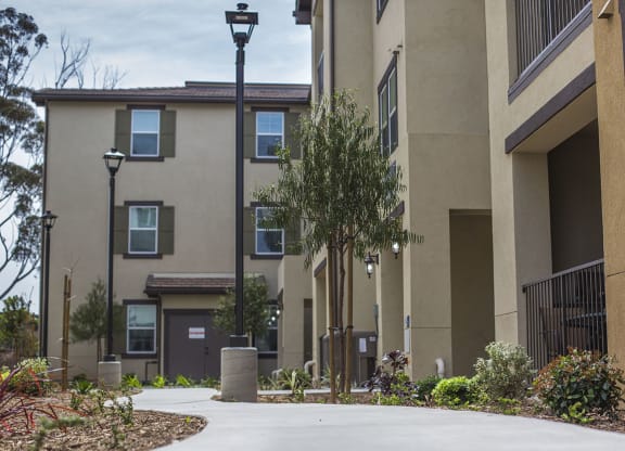 an empty sidewalk in front of an apartment building at Arrive Los Carneros Apartments, Goleta, 93117