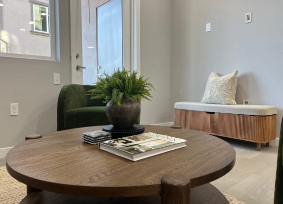 a table with a book and a plant on it in a living room