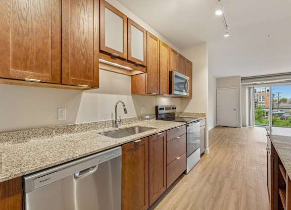 A kitchen with wooden cabinets and a granite countertop.