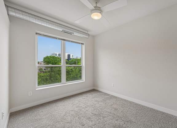 A room with a window and a ceiling fan.