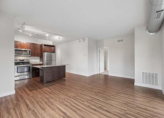 A kitchen with wooden floors and stainless steel appliances.