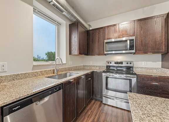 A kitchen with a stainless steel dishwasher and oven.