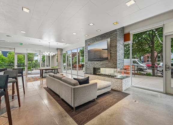 A modern living room with a large couch and a stone fireplace.