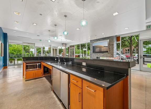 A kitchen with a black counter top and wooden cabinets.