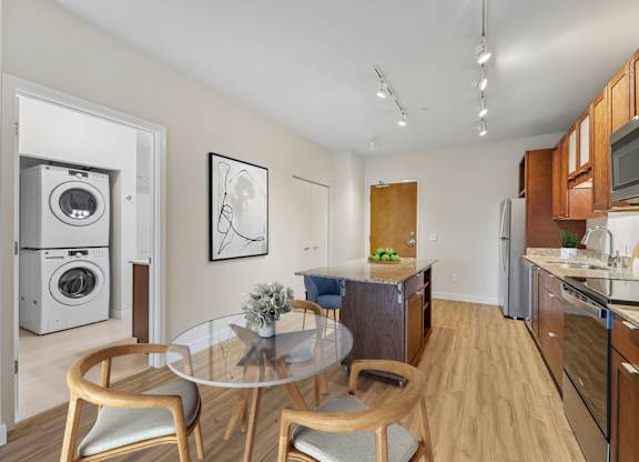 A modern kitchen with a glass table and chairs.