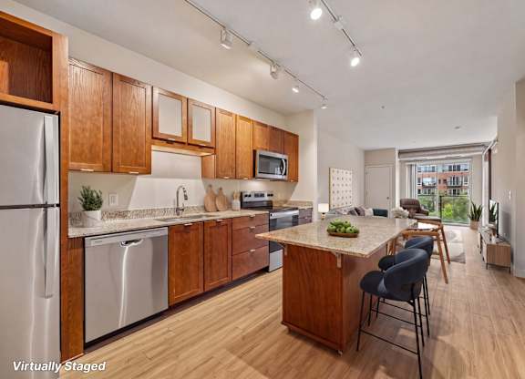 A kitchen with wooden cabinets and a stainless steel refrigerator.