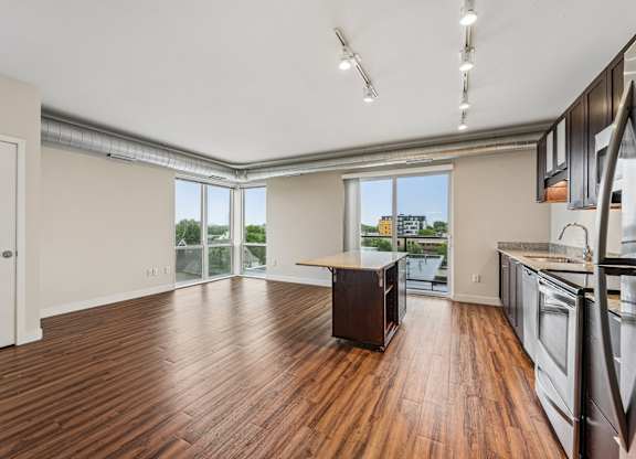 A kitchen with a wooden floor and stainless steel appliances.