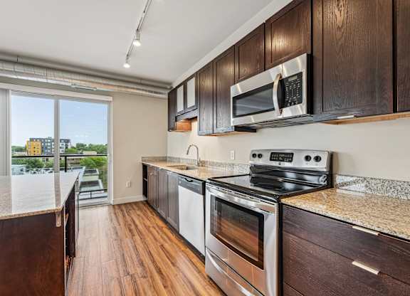 A kitchen with dark wood cabinets and stainless steel appliances.