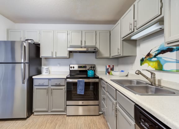 a kitchen with white cabinets and stainless steel appliances