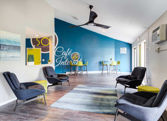 a lounge area with chairs and a rug