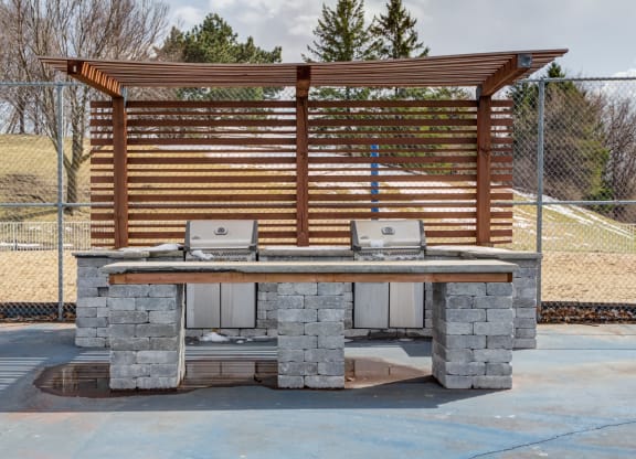 a stone barbecue grill with a wooden awning