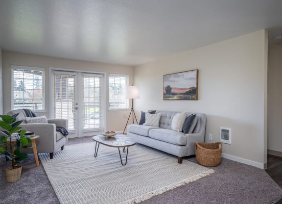 a living room with a couch and a chair and a window at Sundial Apartments, Wilsonville, 97070