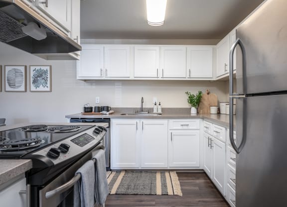 a kitchen with white cabinets and stainless steel appliances at Sundial Apartments, Oregon, 97070