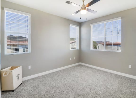 Bedroom with ceiling fan and windows at Arrive Temecula