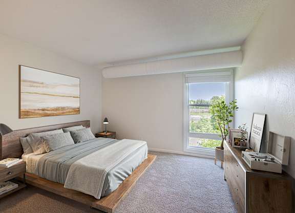 A bedroom with a large bed and a painting on the wall.
