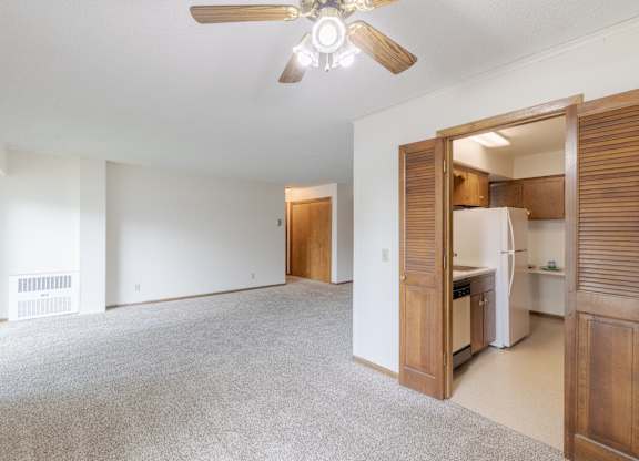 A room with a ceiling fan and a carpeted floor.
