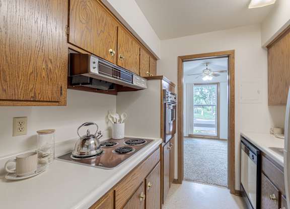 A kitchen with wooden cabinets and a stove top oven.