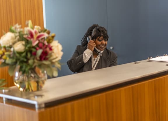 a woman sitting at a desk with a phone to her ear at West77, Chicago, 60654