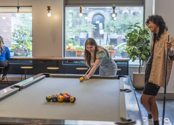 people playing a game of pool  at West77 Apartments, Chicago, IL