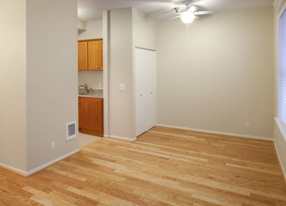a living room with a hard wood floor and a kitchen